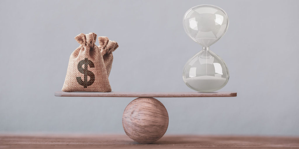 sand clock and bag with dollar sign on a balance scale